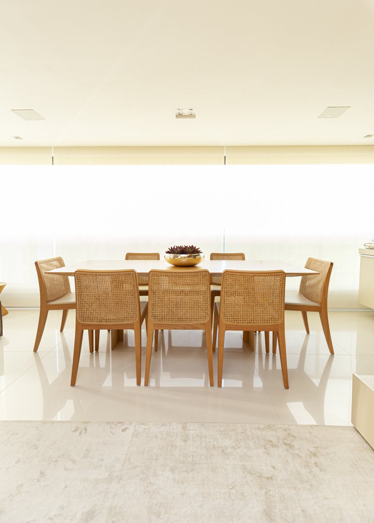 Varanda integrada com piso Portobello Mineral Off White Polido 90x90cm, mesa de jantar e cadeiras (Sollos) e tela solar rolô Uniflex..