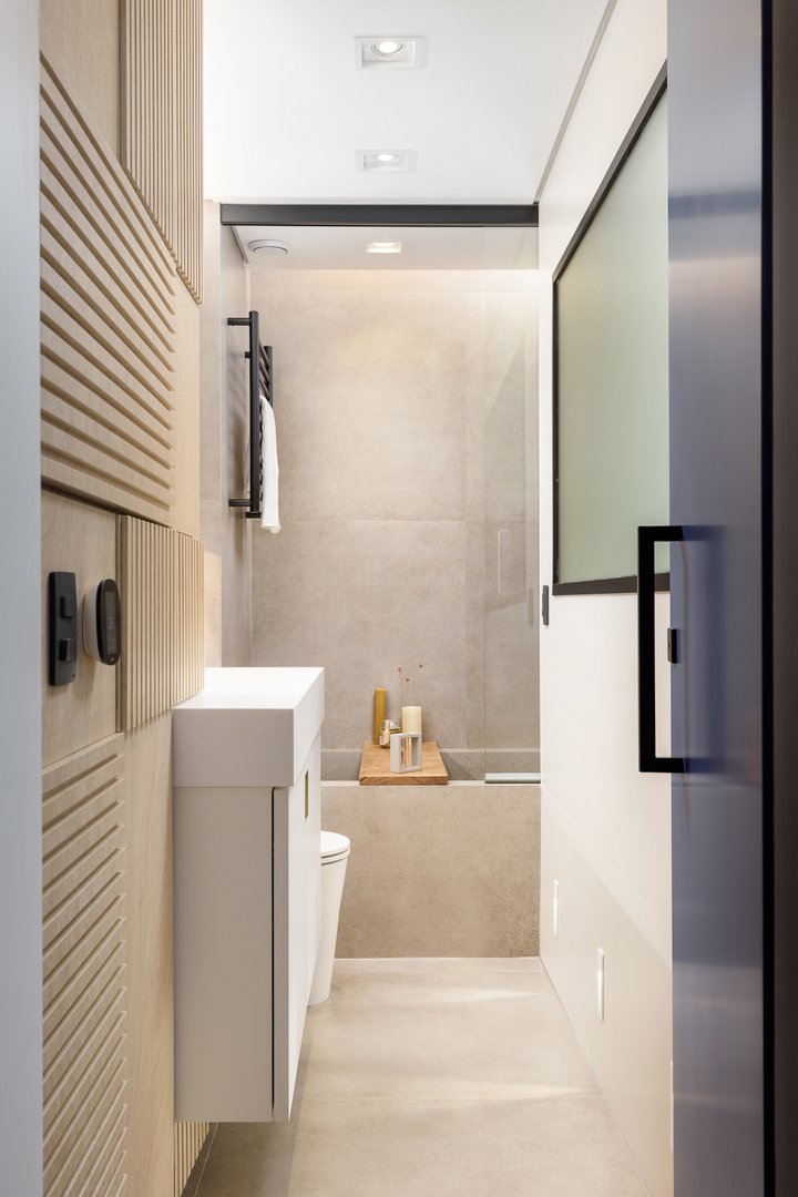 Banheiro com linhas minimalistas, destaque para banheira esculpida no mesmo porcelanato que o piso e a parede.