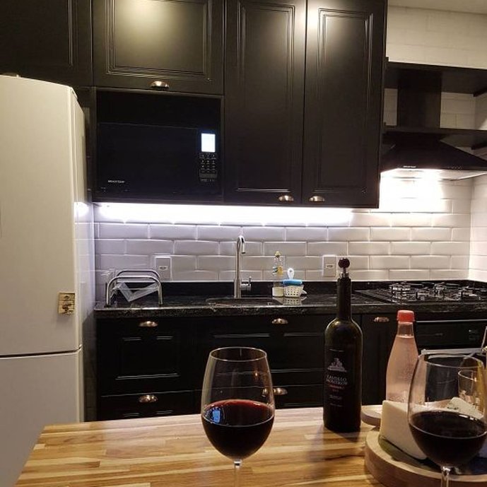 Cozinha com balcão de acesso a sala de jantar, cozinha inspirada na vida cosmopolita de SP.