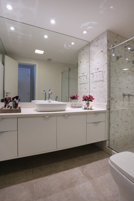 Banheiro suite que equilibra o clássico do mosaico em mármore com o concreto urbano e moderno.