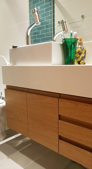 Bancada em Branco Prime com armário em madeira freijó. Piso Pietra di Firenze Grigio. 