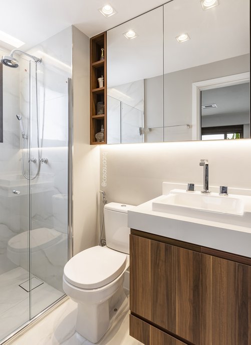 Porcelanato com textura do mármore confere base neutra para o banheiro; a madeira dá o toque final à composição. Foto: Luiz Franco