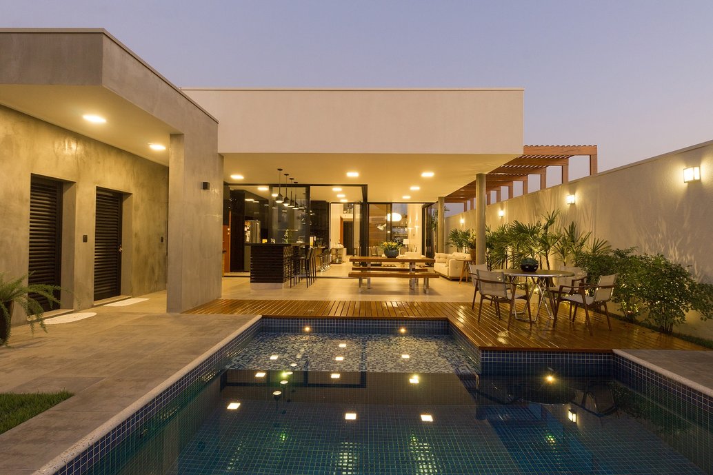 Casa com mínimo de cômodos necessários ao dia-a-dia do casal: única sala de estar e TV e pequena cozinha, ambos espaços ligados à área coberta aberta da casa em formato de ?L? que abriga cozinha gourmet e espaço para refeições, além de espaço de estar com vista para o o jardim no fundo do terreno amplos para reunir os filhos já saídos de casa e suas respectivas famílias. Como desejo do proprietário que esse espaço de estar e lazer da família configurasse-se como um grande ?rancho?, optou-se por cobertura em telhado em estrutura de madeira aparente e telha de barro com forro de madeira e por materiais como o tijolo feito à mão por olaria carioca e porcelanato italiano com aspecto rústico porém. Assim o conceito de ?rancho? tradicional foi utilizado com materiais nobres e atuais, conferindo um aspecto bastante original à construção.
