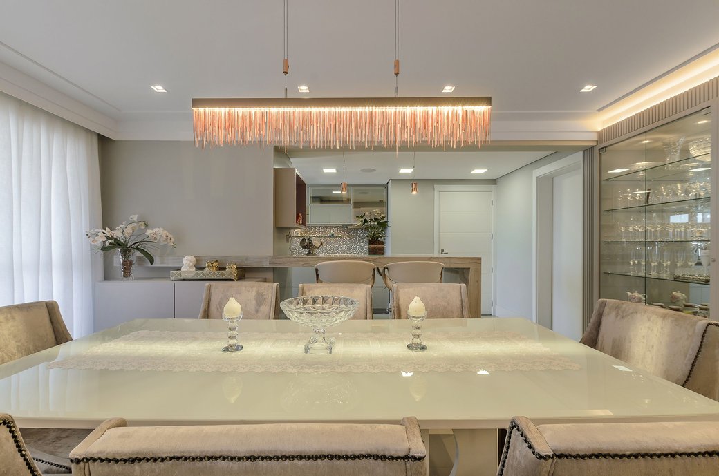 Visual do living mostrando a cristaleira e a cozinha. Luminária moderna. Sala de jantar clara branca.