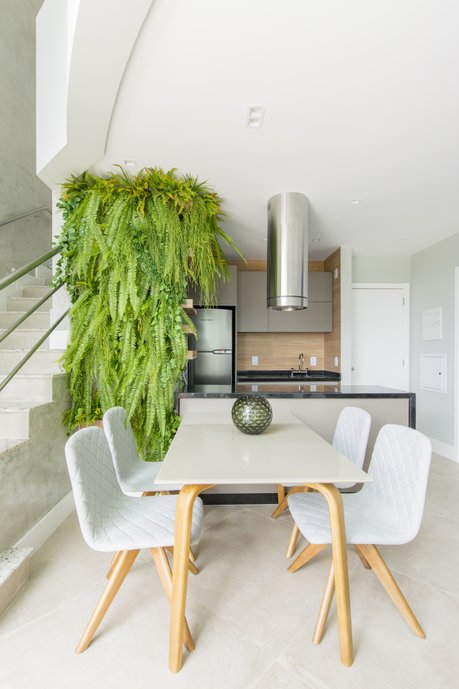 Detalhe pro jardim vertical ao lado da mesa de jantar incorporada ao balcão da cozinha.