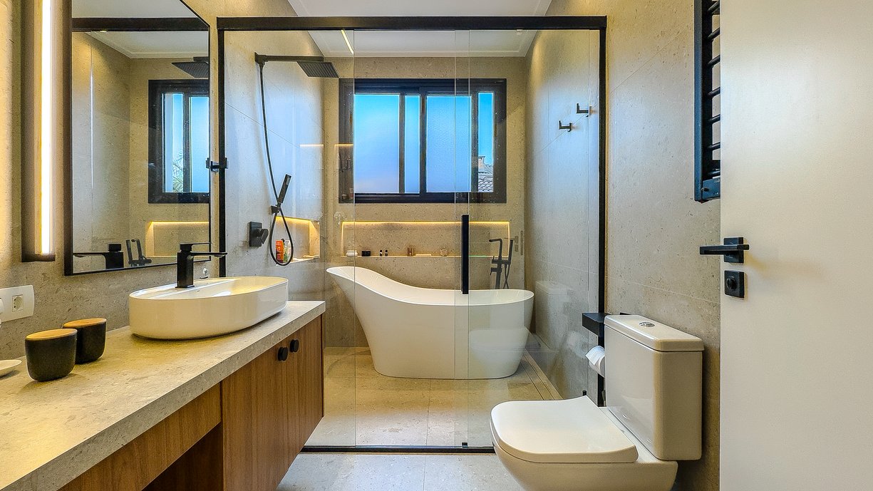 Banheiro da suíte do casal com a bancada em porcelanato igual ao revestimento e piso dando um ar de sofisticação e neutralidade.