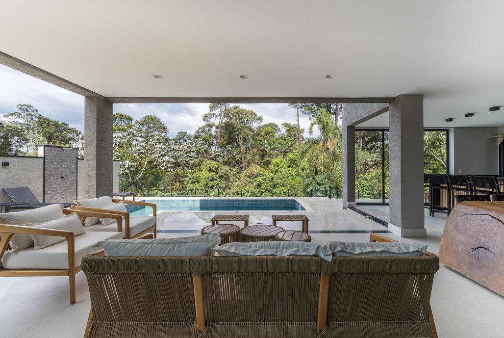 Área de lazer com mata ao fundo.