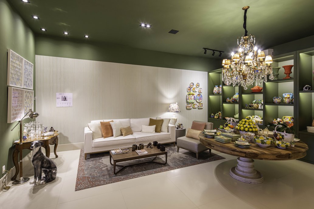 Para as paredes e o teto, foi escolhido um tom escuro, para dar destaque aos produtos em exposição. Com o objetivo de contrastar com as paredes e trazer luminosidade ao ambiente, foi escolhido um porcelanato claro para o piso. 