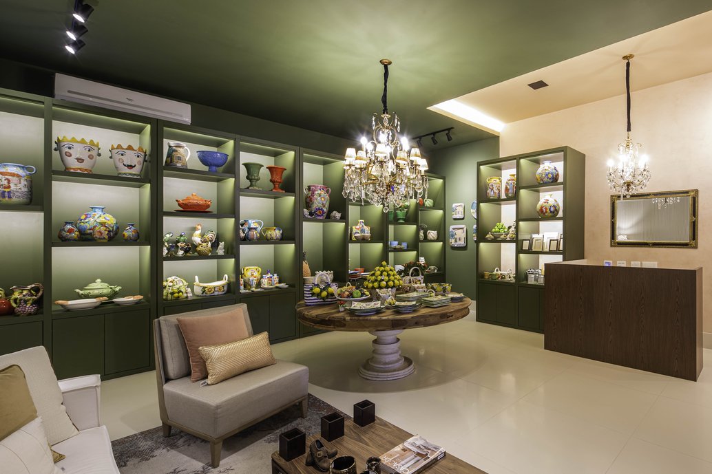 Para as paredes e o teto, foi escolhido um tom escuro, para dar destaque aos produtos em exposição. Com o objetivo de contrastar com as paredes e trazer luminosidade ao ambiente, foi escolhido um porcelanato claro para o piso. 