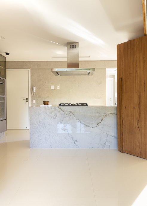 Cozinha com piso Portobello Mineral Off White Polido 90x90cm, bancada em Quartzito Tarento e esquadria com lâmina de madeira freijó natural.
