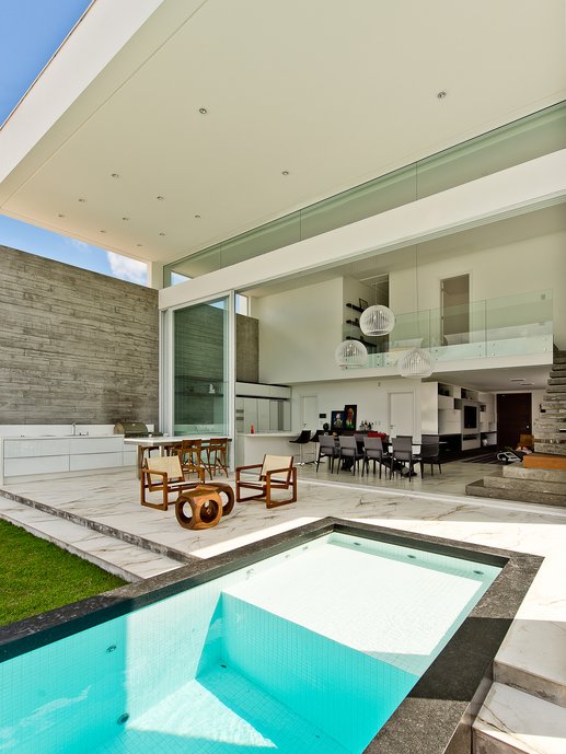 Área externa integrada ao espaço gourmet, com piscina sobreposta à varanda. Porcelanato: Bianco Paonazzetto.