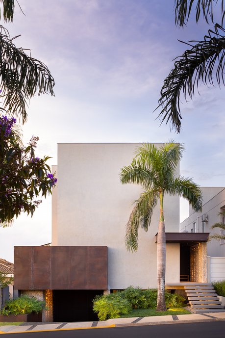 Fachada minimalista com empena em concreto aparente e corten