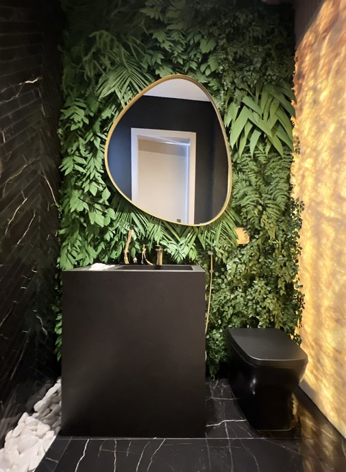 Lavabo preto com Nero Venato Portobello Shop no piso e detalhe na parede, jardim vertical, parede iluminada. 