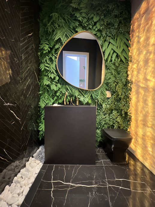 Lavabo preto com Nero Venato Portobello Shop no piso e detalhe na parede, jardim vertical, parede iluminada. 