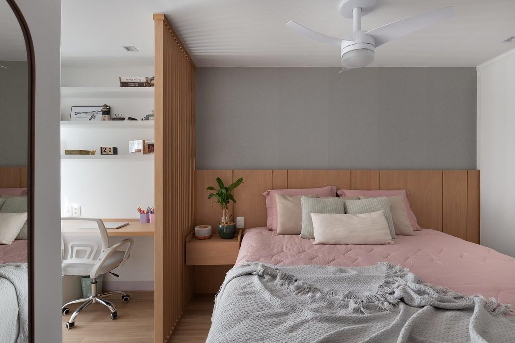 quarto principal com espaço de home office e piso em araucaria