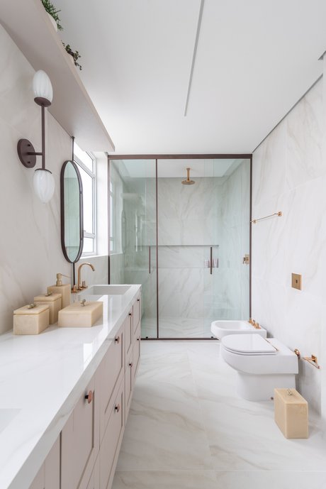 Banheiro amplo todo revestido em Bianco Covelano natural