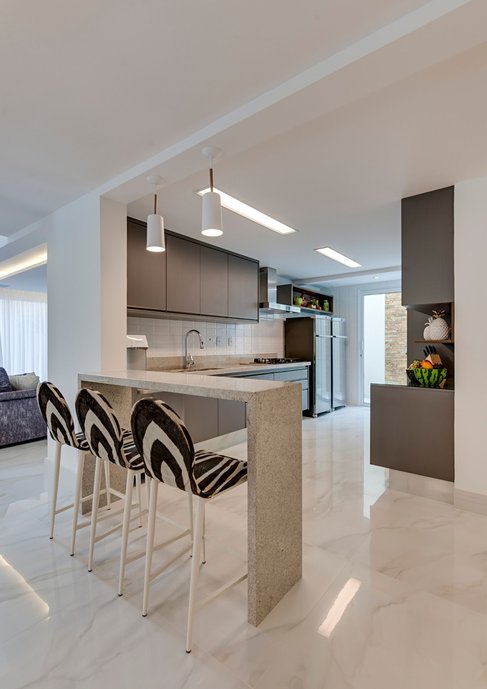 Cozinha integrada de uma casa de praia, com o piso em porcelanato Bianco Covelano 90 X 90
