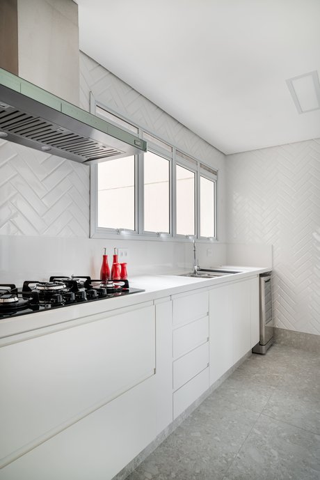 Cozinha moderna com tons de branco e cinza. Utilizamos o Liverpool White na paginação espinha de peixe, trazendo um toque diferente à cozinha! Foto: João Friederichs
