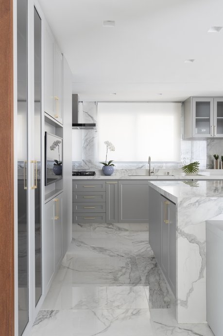 Cozinha com estilo clássico, bancadas e ilha esculpida em porcelanato.