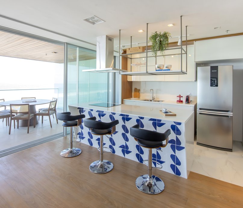 Cozinha em conceito aberto para sala com balcão de refeições onde a frente forma um painel decorativo