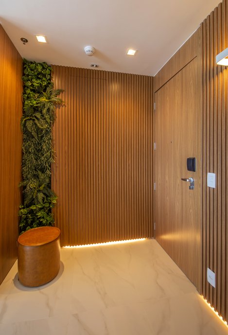O hall social dá as boas vindas com um lindo jardim vertical e piso nobre