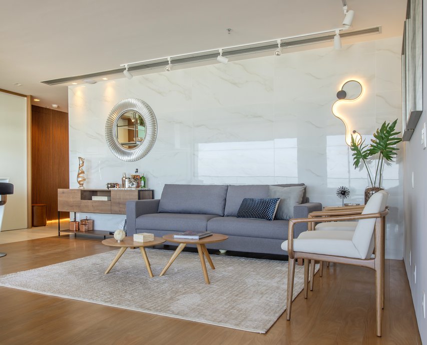 O painel do living em porcelanato polido funciona cria o efeito de um espelho