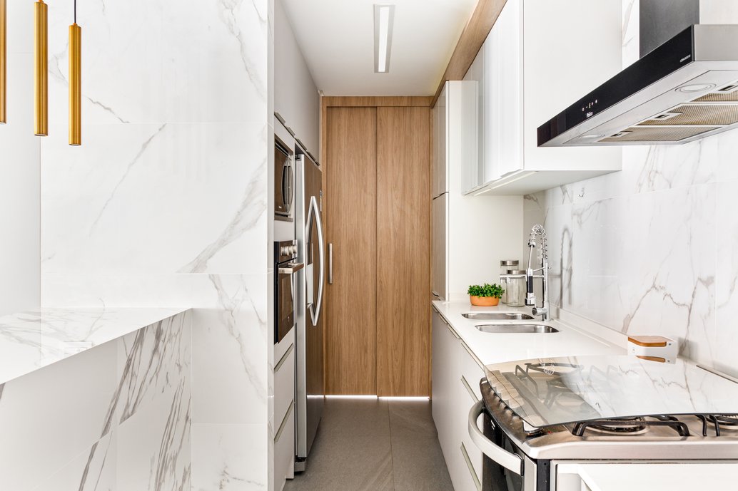 Cozinha clean, revestida em porcelanato marmorizado branco, com toque amadeirado para aquecer! 