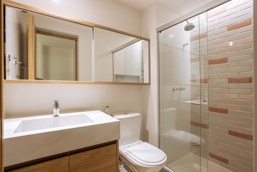 Banheiro com bancada em porcelanato e painel em tijolinho