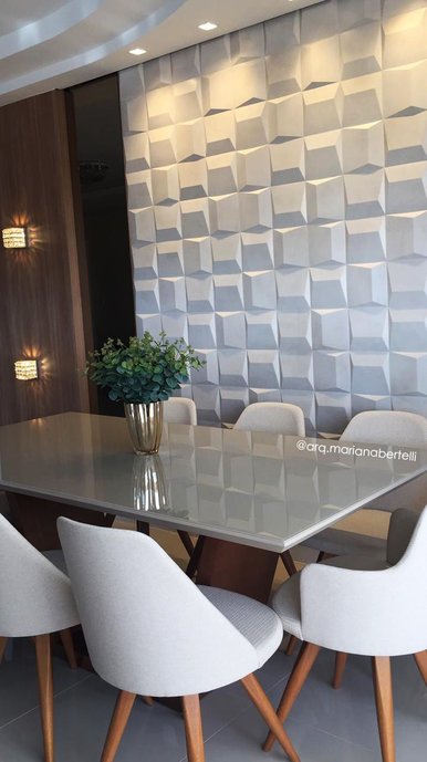 Sala de jantar com revestimento Spot Montain Cru da linha Lab 3D como destaque. A paginação personalizada com pontos de iluminação destacando-a deu maior movimento as peças.