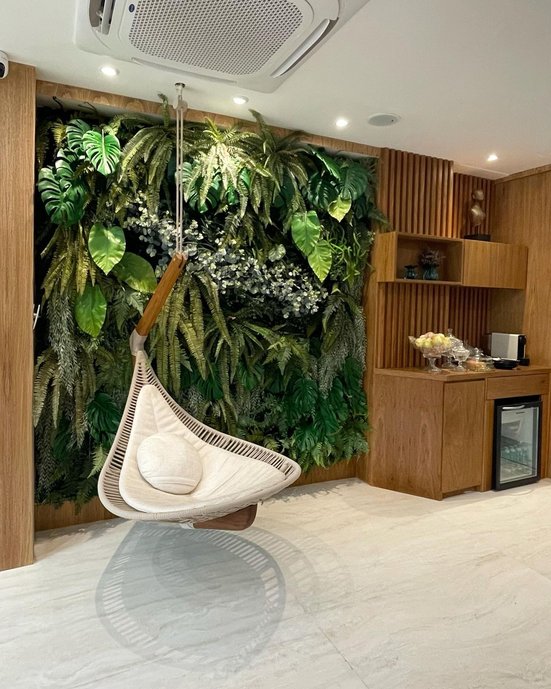 Cadeira pendente no teto; Biofilia em espaço comercial.