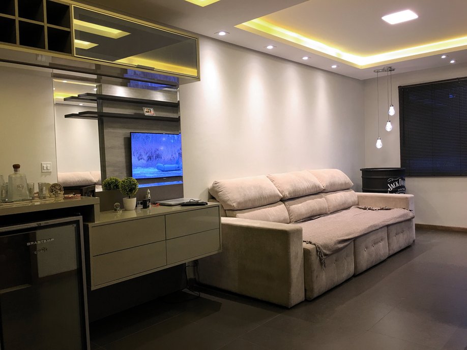 Sala de um jovem solteiro, onde utilizamos tons de cinza e preto para transformar a sala em um ambiente neutro e masculino, e a iluminação com diversas possibilidades de configuração traz o aconchego para cada momento.