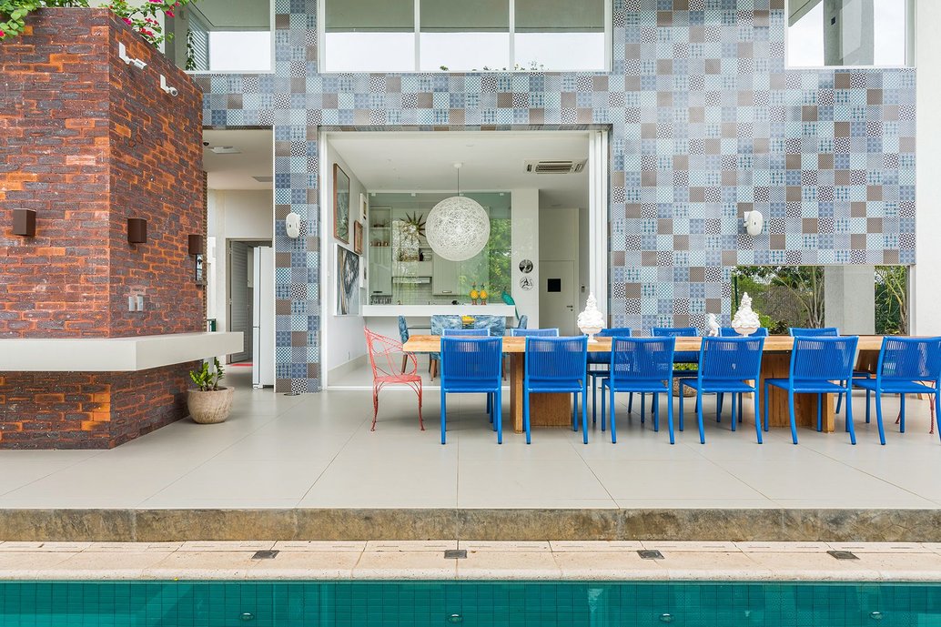 Vista da área externa com piscina e terraço e ao fundo sala e cozinha integrados. Foto: Manoel Soares
