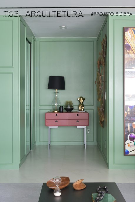 Com muita personalidade esse hall de entrada mescla cores modernas com elementos de design clássico como o boiserie e o aparador de linhas curvas. O verde com o terracota criam um visual único e marca; boiserie verde, decoração verde e rosa