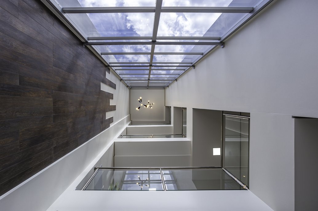 Hall de entrada de edifício comercial em tons neutros e revestimentos na parede marmorizados que dão um toque especial aos pacientes e doutores que ali transitam.