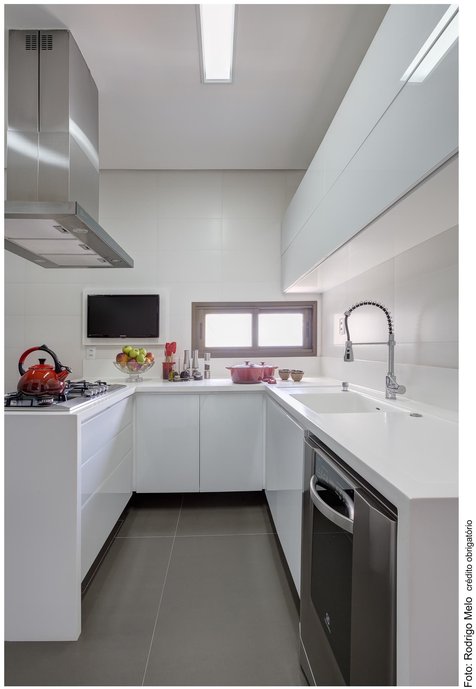 O piso escuro em contraponto com paredes brancas cria profundidade ampliando a cozinha