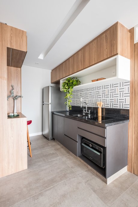 Cozinha bem compacta integrada ao Living , aqui temos um cooktop e um forno flex que serve tanto como forno elétrico , como também como microondas. Ideal para pequenos espaços, assim foi possível garantir espaço para os armários dispensas e outros usos.