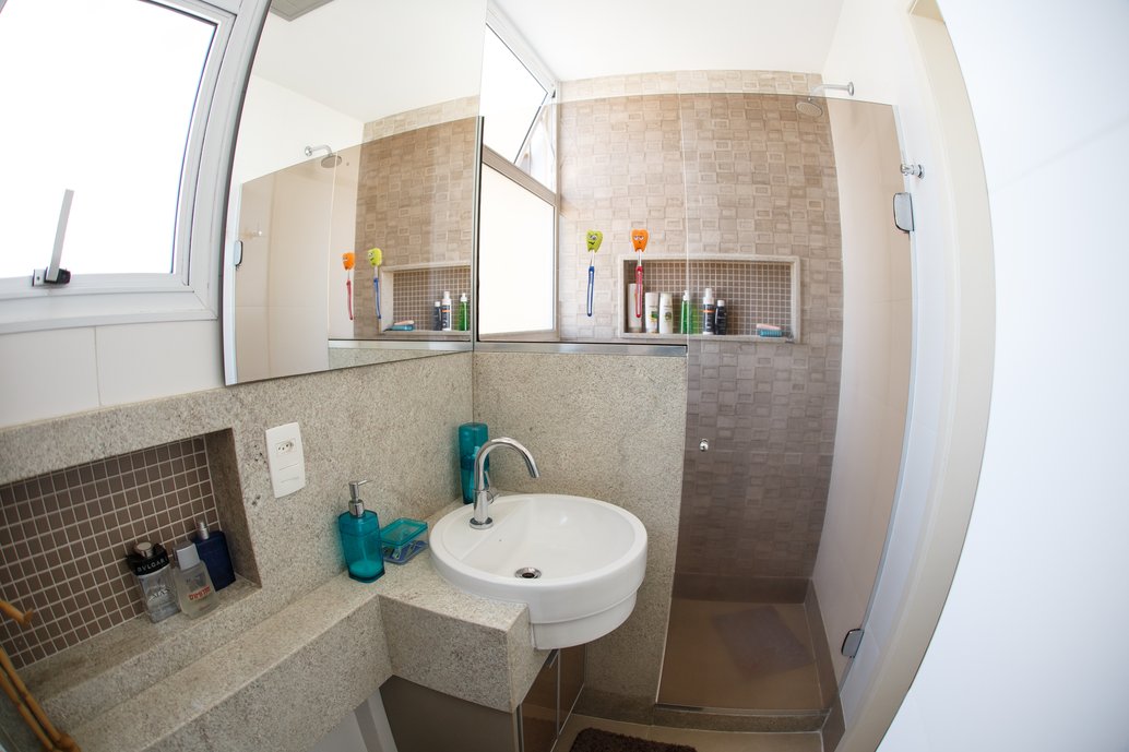 Este banheiro criamos a partir da área de serviço de um apartamento, para atender aos filhos jovens do casal. Para dar o ar prático e despojado, apostamos em materiais versáteis como os detalhes com block cream , o destaque do box com relevo concreto e o piso pietra de firenza camel.