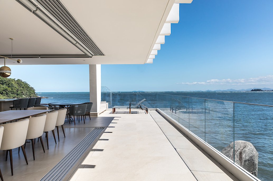 A leveza do branco foi mantida na proposta de interiores, seguida na cozinha e na bancada toda branca, como também os revestimentos da Portobello.