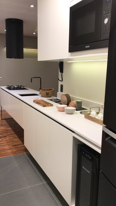 REFORMA DE COZINHA E LAVANDERIA DE APARTAMENTO COM MANUTENÇÃO DO PISO DE MADEIRA ORIGINAL DA SALA PARA ONDE FOI EXTENDIDA PARTE DA BANCADA DA COZINHA
