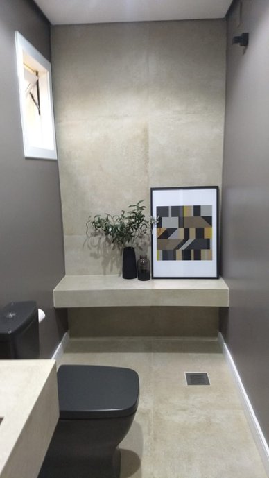Lavabo clean com revestimento estilo concreto e bancada de cuba esculpida.