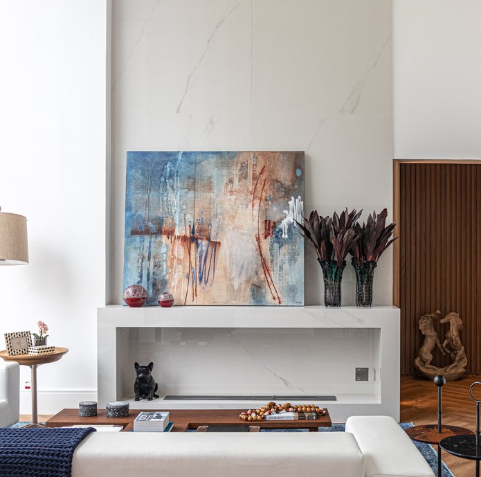 Lareira à gás feita no ateliê Portobello, com painel do mesmo material indo até o teto, preenchendo o pé direito duplo