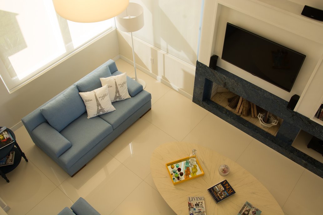 Living descontraído em casa do litoral norte do Rio Grande do Sul. Com base branca, Simplesmente branco 90x90 POL, com detalhes em azul na decoração em móveis e objetos.