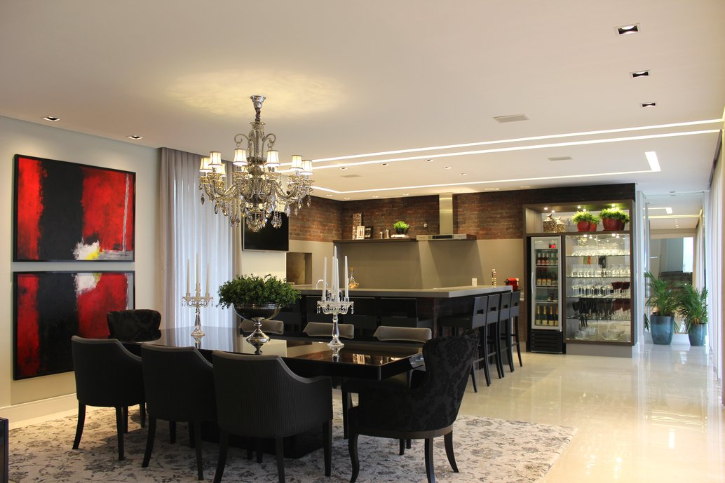 Sala de jantar integrada com churrasqueira e espaço gourmet.