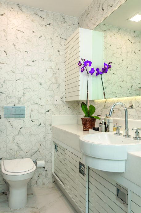 Lavabo branco com detalhes em relevo nas paredes principais.