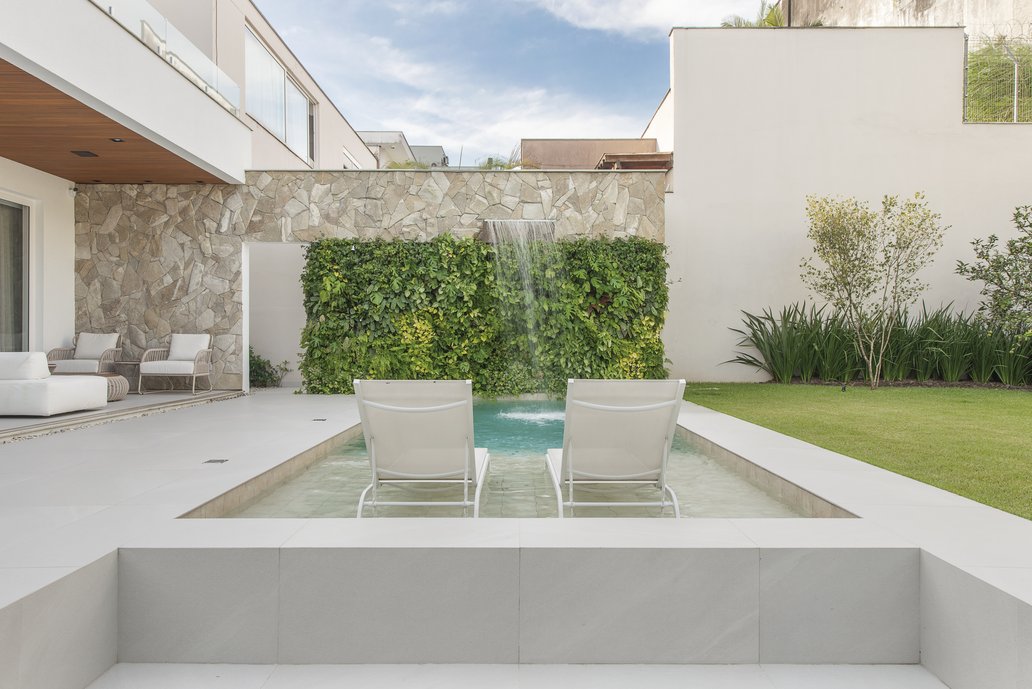 Composição de espaço externo, com elementos naturais como jardim e pedra moledo compondo com piso portobello.