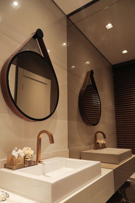 Um banheiro espelhado e com iluminação adequada.