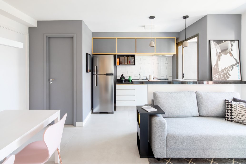 Cozinha integrada com a sala de estar. Os ambientes possuem uma marcenaria minimalista, utilizando linhas ortogonais por todo projeto.