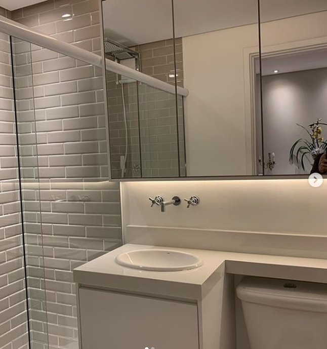 Banheiro simples porém com detalhes acolhedores como a iluminação, revestimento.