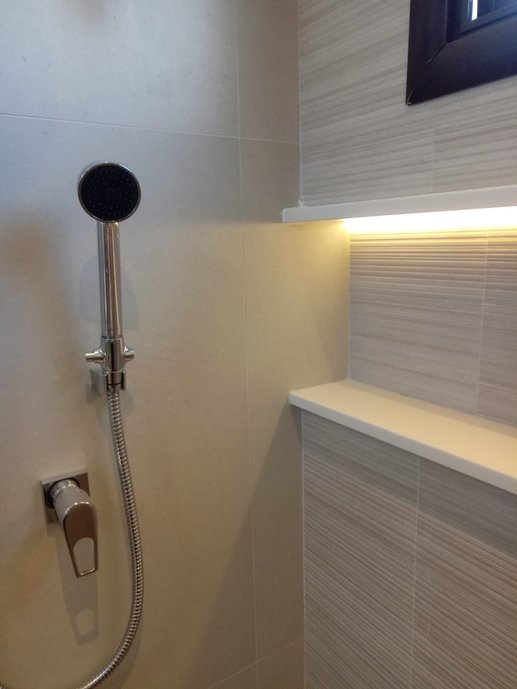 Banheiro da filha com nicho em porcelanato e iluminação
