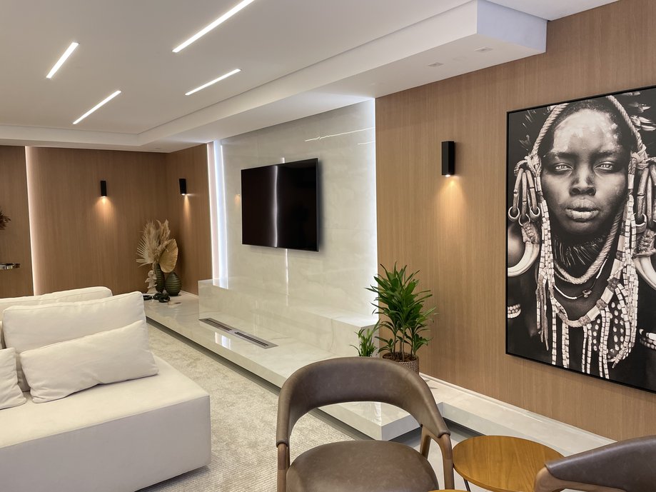 Painel de tv todo em porcelanato, integrado com lareira a gás em porcelanato esculpido.